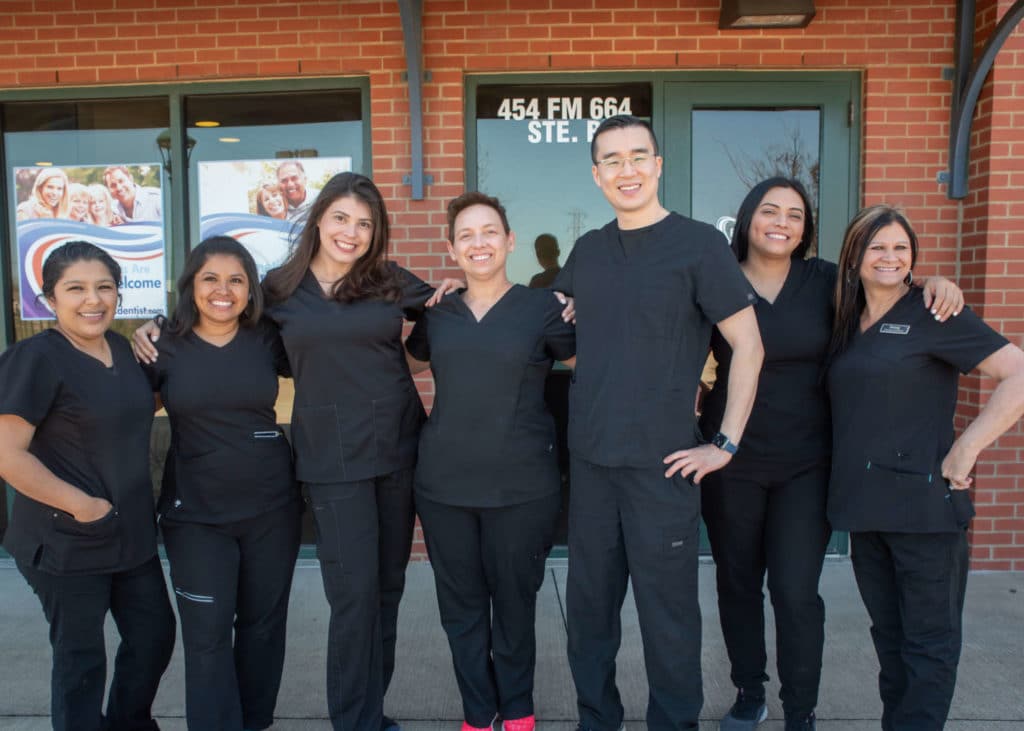 dentists in Ferris Texas standing in front of a dental office with their dental team